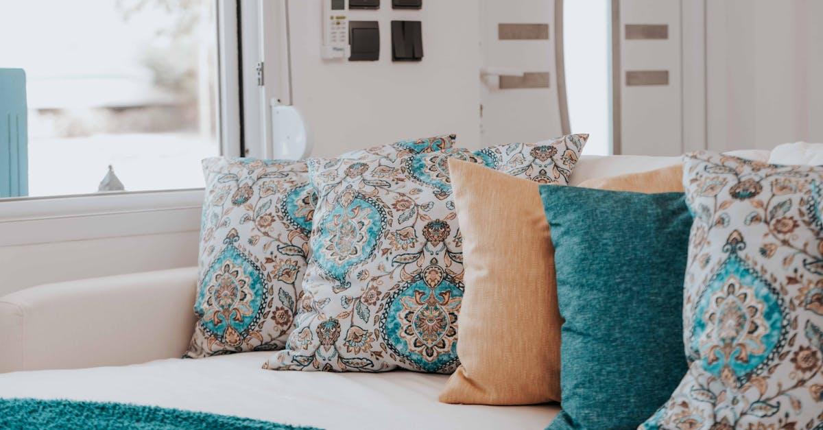 Aksamitne poduszki do szarej kanapy — paleta kolorów i triki stylistów, które odmienią salon