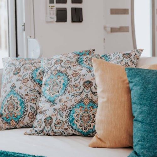 Aksamitne poduszki do szarej kanapy — paleta kolorów i triki stylistów, które odmienią salon